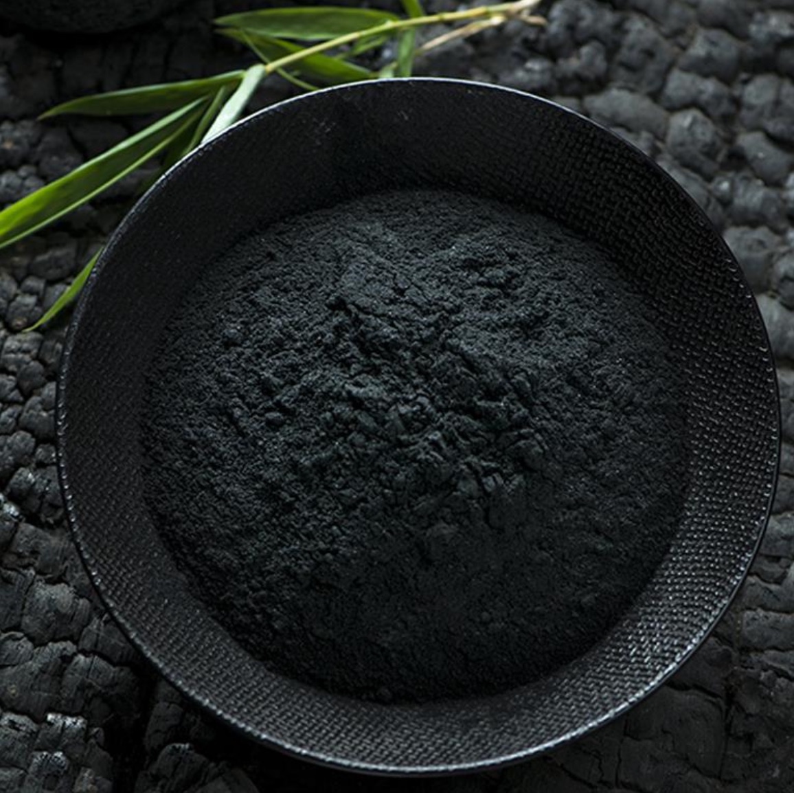 Premium powdered activated carbon presented in a black bowl