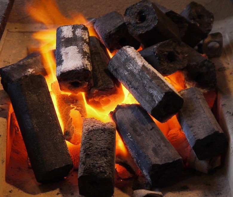 Charcoal briquettes burning with a clean orange flame